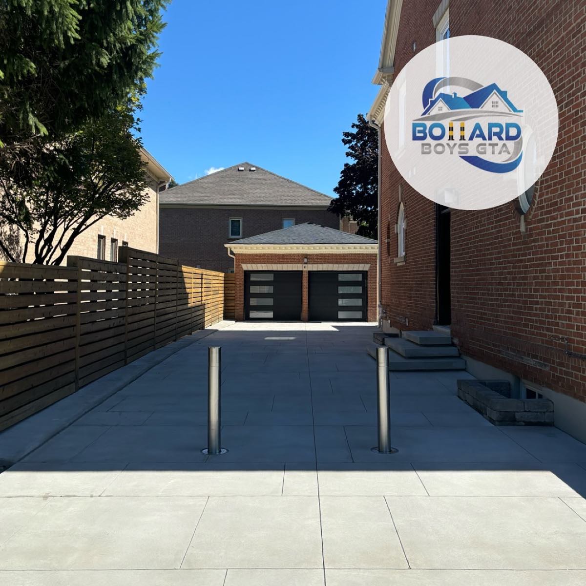 Two stainless bollards securing a rear laneway driveway